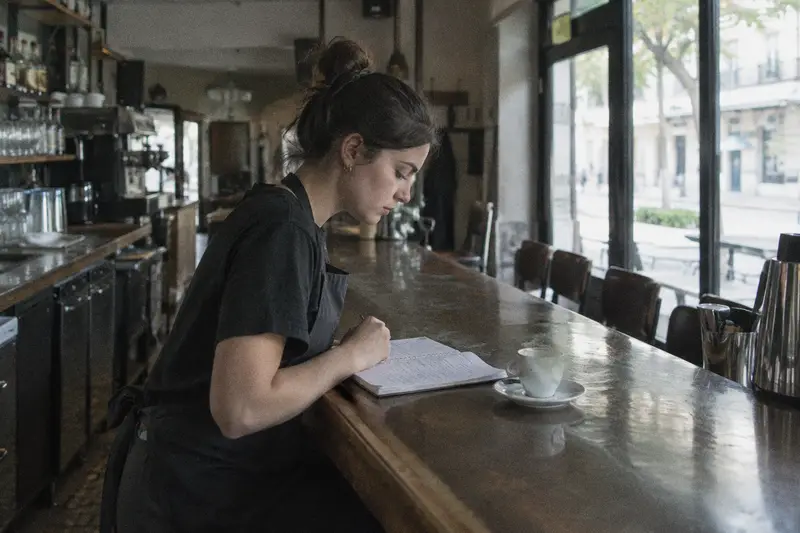 Una camarera repasa sus apuntes en la barra de un bar vacío antes de abrir